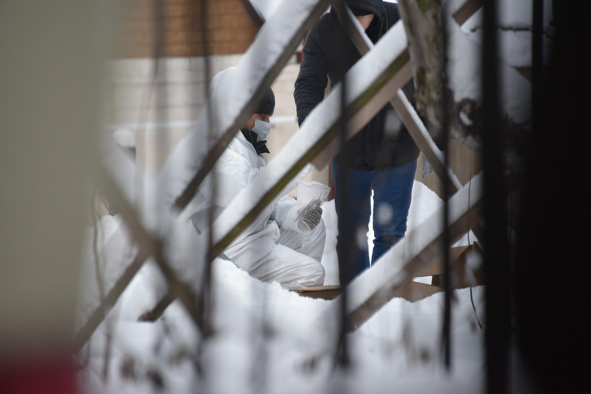 Трое экспертов в спецкостюмах работают на месте взрыва у дверей гимназии. Собирают со снега вещдоки, кладут в пакеты, а пакеты — в коробки. Фото: Анастасия Цицинова / для «Новой»