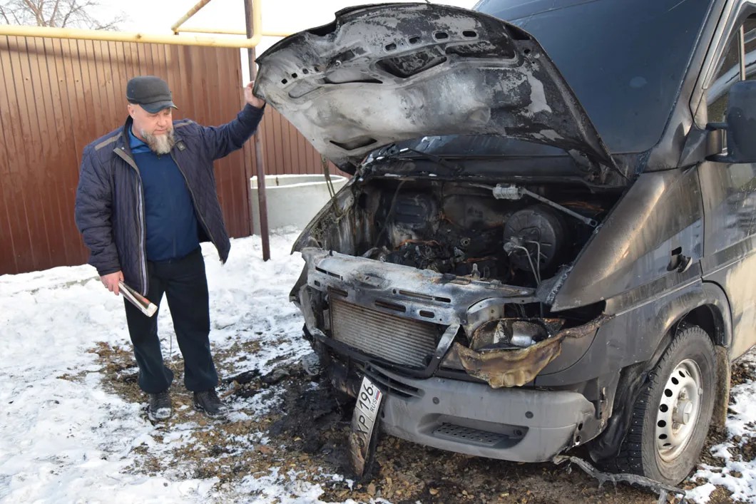 Виктор Джупина со своим сгоревшим автомобилем. Фото: Изольда Дробина