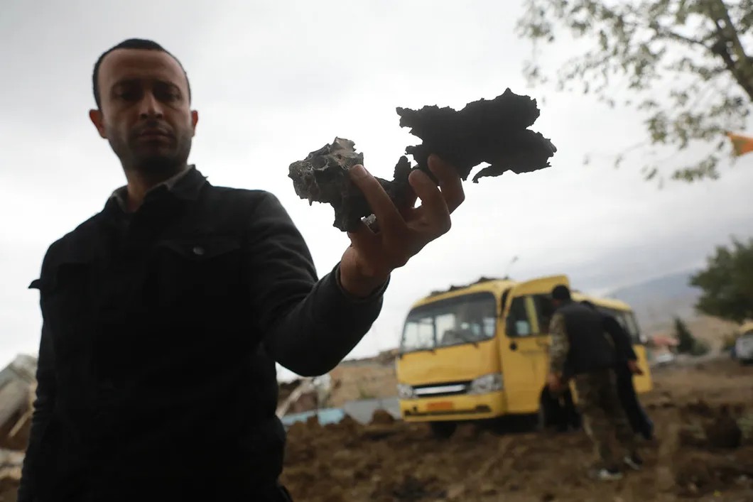 Местный житель показывает осколок снаряда. Фото Павел Волков, специально для «Новой»