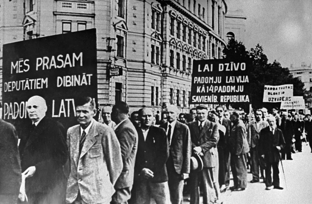Колонны демонстрантов с надписями на транспарантах: «Мы просим депутатов учредить Советскую Латвию», «Да здравствует Советская Латвия» идут по улицам Риги, 1940 год. Фото: РИА Новости