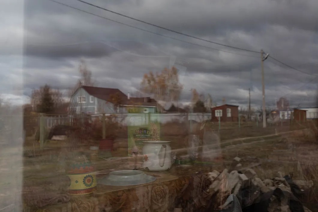 В окне — отражение деревни Вяхирево (Шатурский район) и оставленная на столе на кухне овсянка. Фото: Виктория Одиссонова / «Новая»