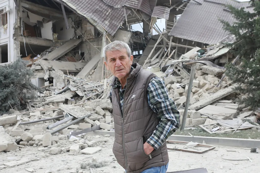 Местный житель на фоне разрушенного здания. Фото Павел Волков, специально для «Новой»