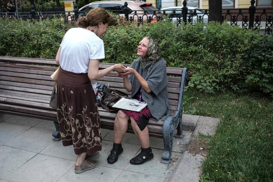 Участница акции делится тортом с женщиной на Рождественском бульваре. Фото: Влад Докшин / «Новая газета»