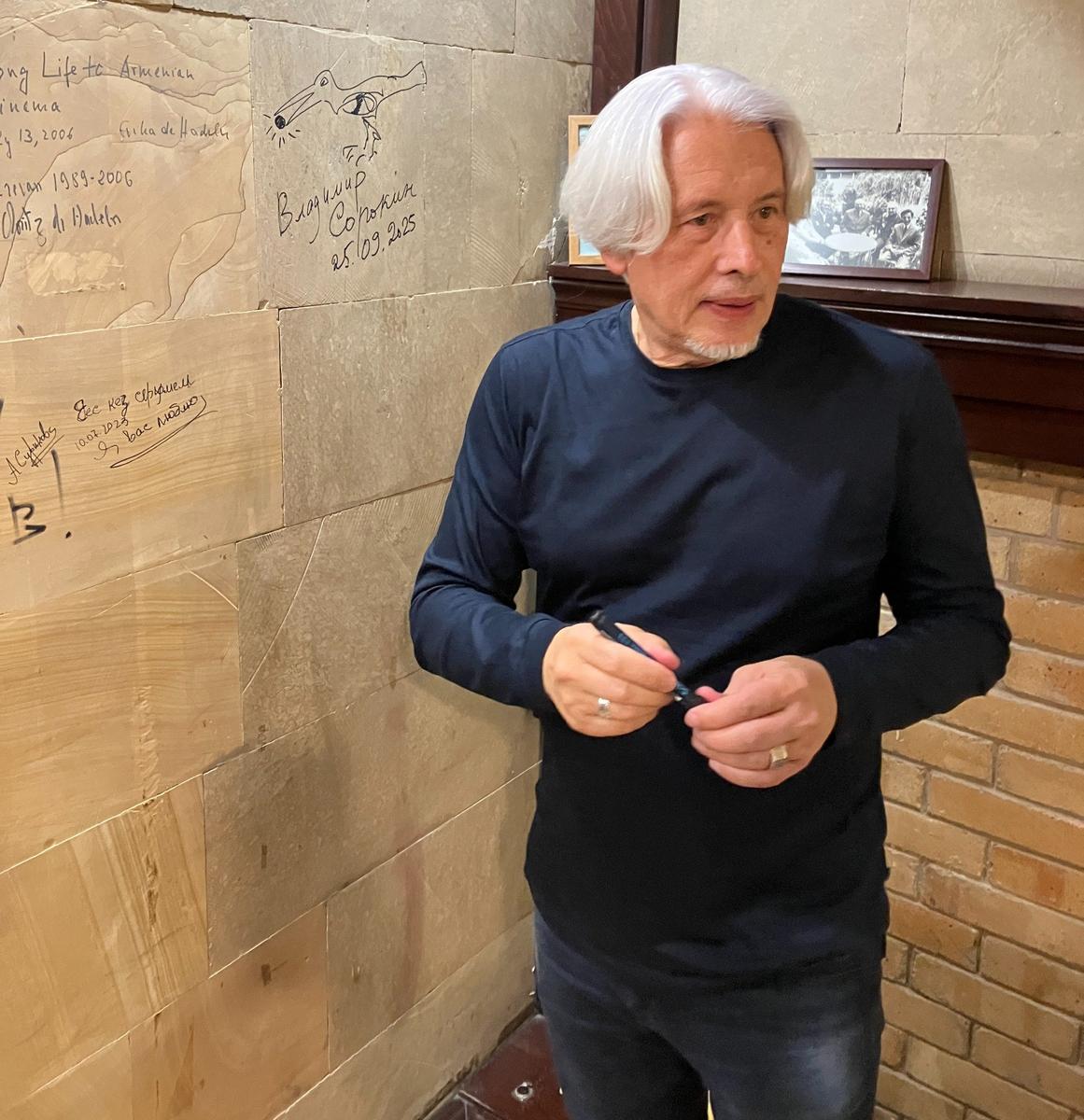 Владимир Сорокин оставил автограф на стене зала Параджанова после встречи с читателями. Фото: Оксана Мисирова / «Новая газета»