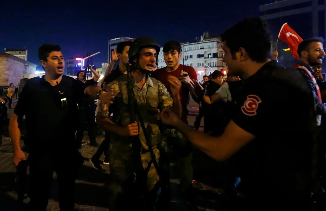Турецкие солдаты сдают оружие сотрудникам полиции во время попытки государственного переворота на площади Таксим. Стамбул, июль 2016 года. Фото: Reuters