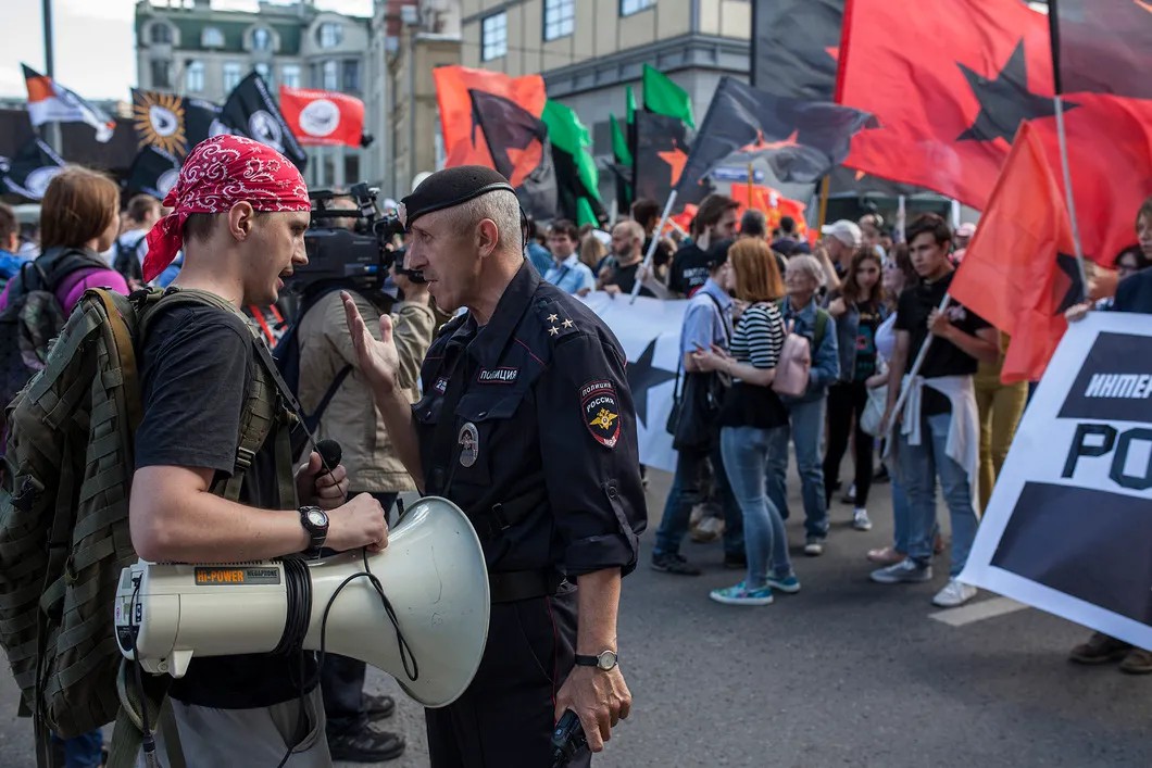 Сотрудник полиции дает инструкции лидеру колонны представителей левого движения. Фото: Влад Докшин / «Новая газета»
