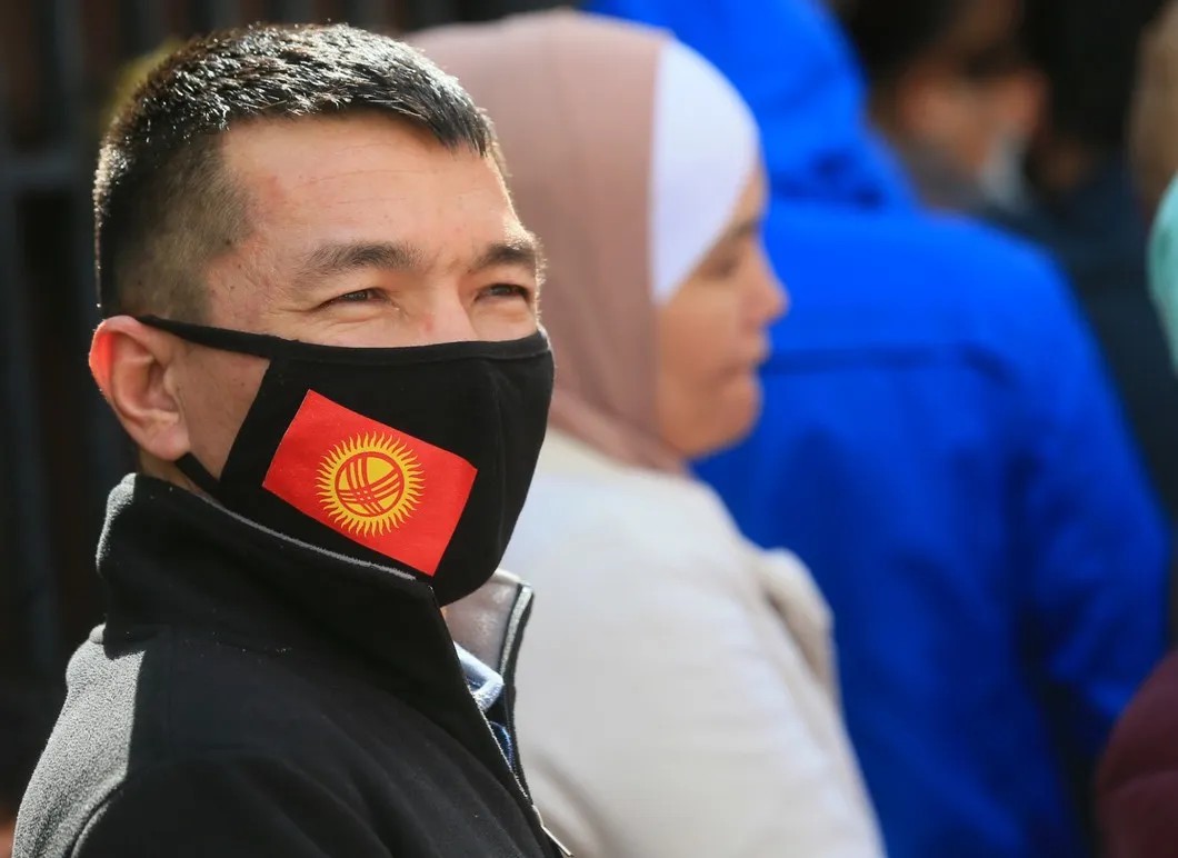 Гражданин Киргизии в защитной маске с национальным флагом, Москва. Фото: Василий Кузьмиченок / ТАСС
