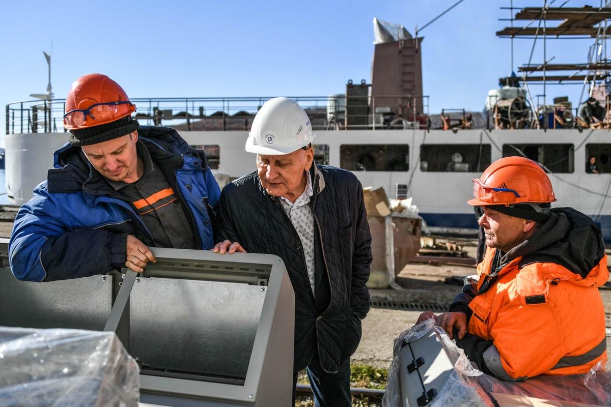 Генеральный директор судостроительного предприятия АО «Восточная верфь» Геннадий Лазарев (в центре) и рабочие предприятия во время проверки строительства морских судов. Фото: Юрий Смитюк / ТАСС
