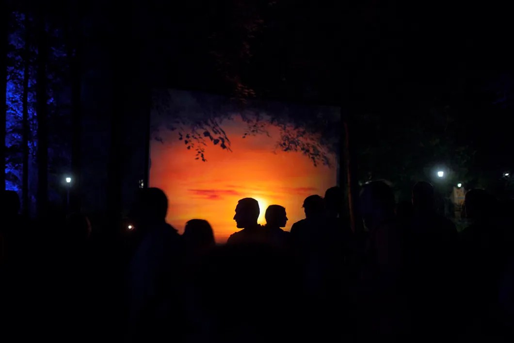 Посетители Останкинского парка напротив экрана, на который проецируются изображения саваны «волшебного леса». На фестивале представлена обширная светопроекционная программа. Фото: Влад Докшин / «Новая газета»