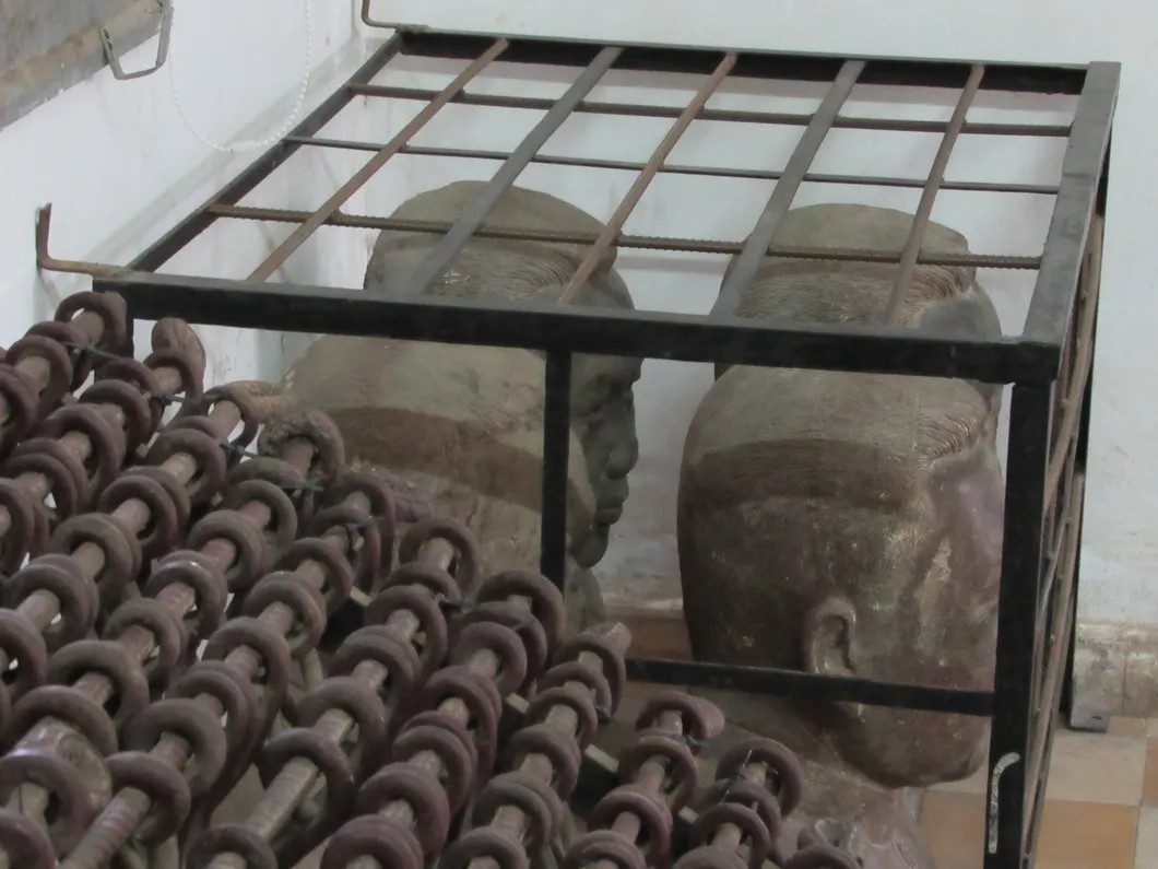 Пол Пот в зале музея. На переднем плане — кандалы, в которые заковывали узников. Фото: автора