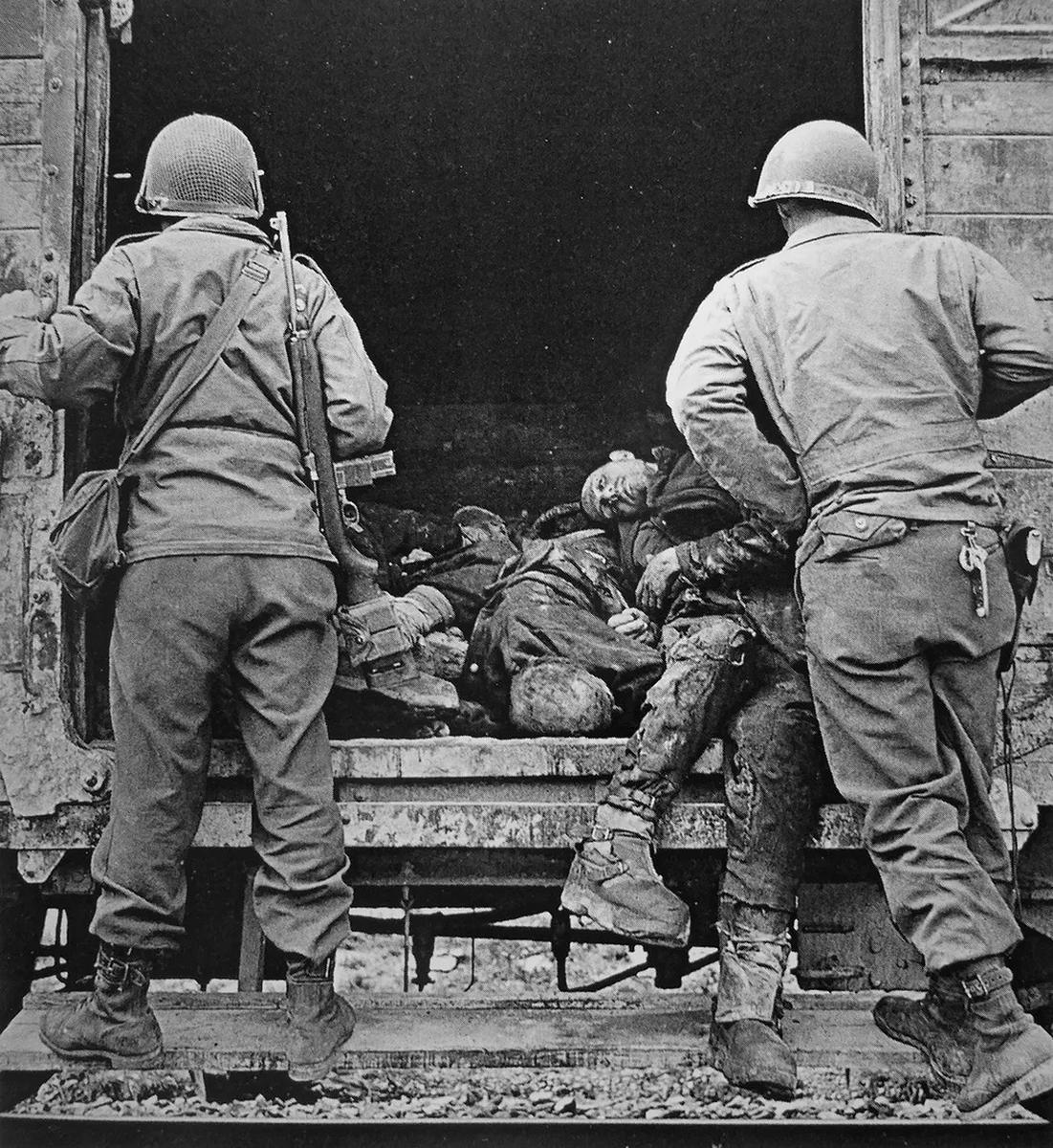 Американские солдаты у вагона с телами погибших узников вблизи концлагеря Дахау, 1945 год. Фото: Lee Miller