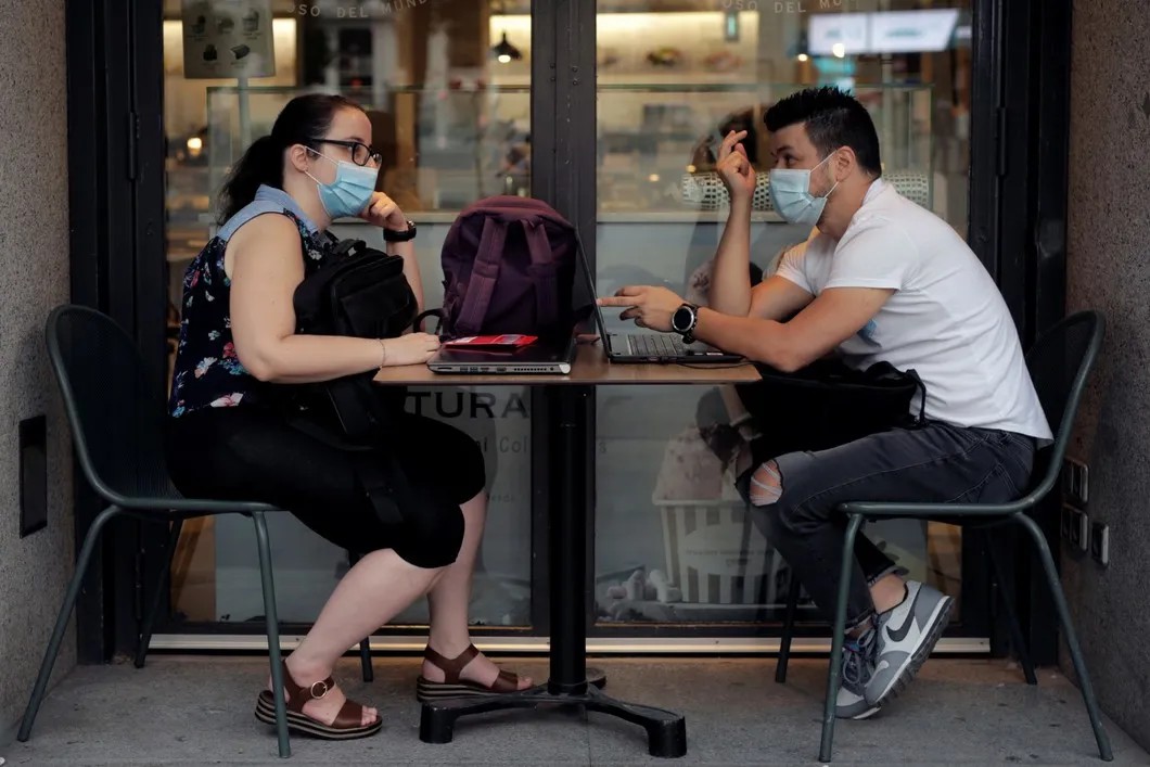 Посетители кафе в защитных масках, Испания. Фото: Reuters