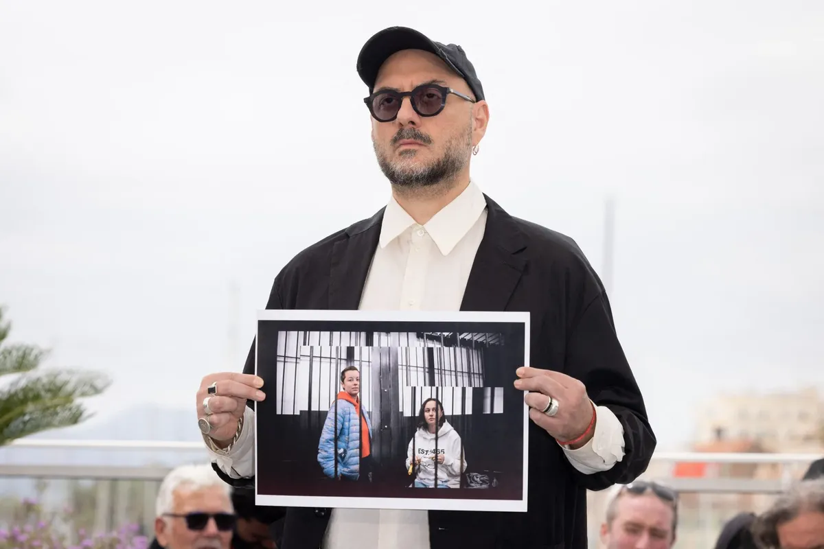 Кирилл Серебренников держит фотографию в поддержку Евгении Беркович и Светланы Петрийчук на фотосессии съемочной группы фильма «Лимонов, баллада об Эдичке» в рамках 77-го международного Каннского кинофестиваля. Фото: Shootpix / ABACA