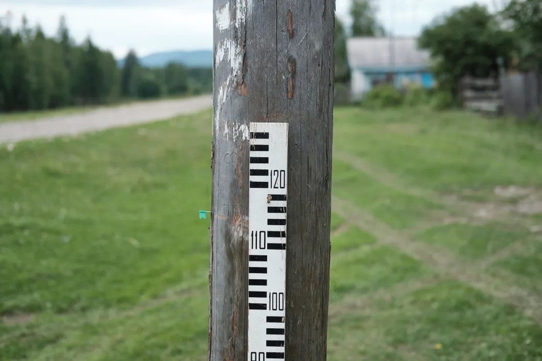 Столб с отметками уровня воды рядом с домом местного гидролога Труфанова, деревня Аршан. Фото: Антон Карлинер, специально для «Новой»