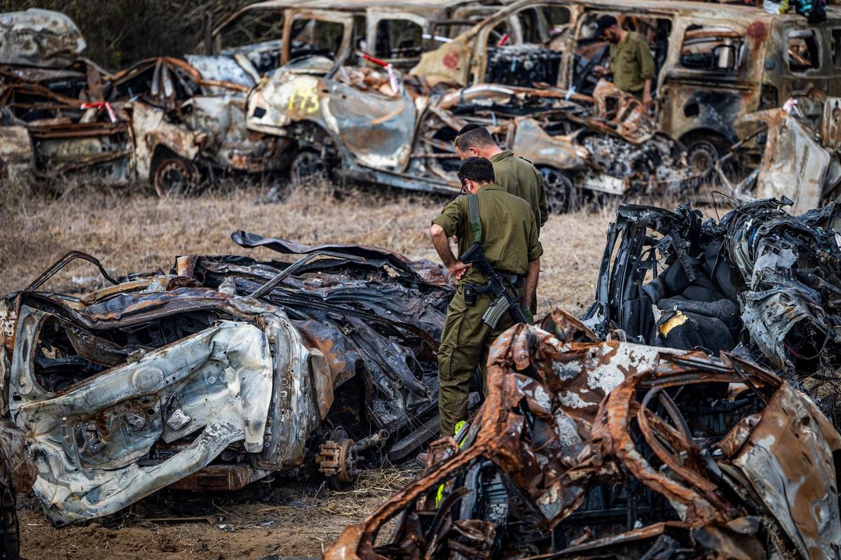 Израильские военнослужащие осматривают автомобили, сожженные боевиками ХАМАС 7 октября недалеко от города Нетивот на границе с сектором Газа. Фото: dpa / picture-alliance