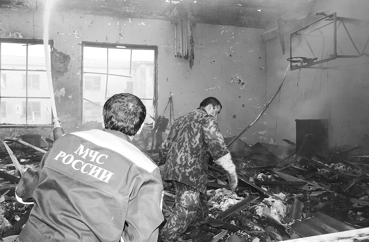 Спасатели осматривают помещение спортзала после штурма и пожара. Фото комиссии по расследованию причин трагедии в Беслане