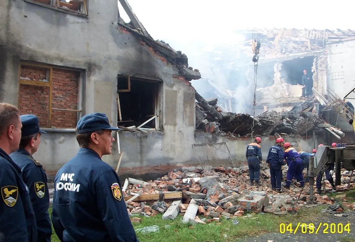 МЧС под руководством Сергея Шойгу (слева) занимается разбором завалов утром 4 сентября 2004 года, в этот день Беслан посетит президент Владимир Путин