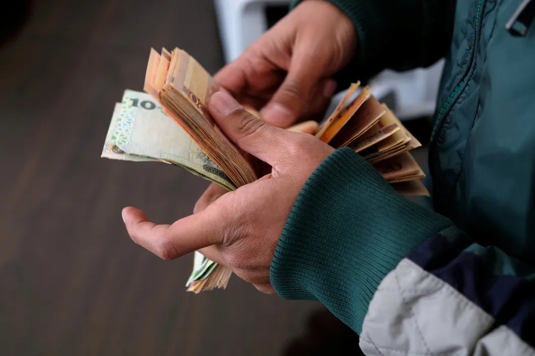 Покупатель пересчитывает ливийские динары. Фото: Reuters