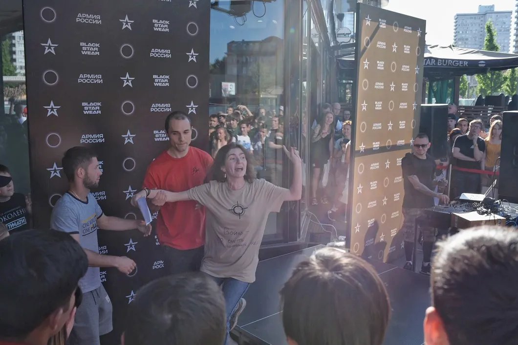 Элизабетта Корси выбежала на площадку рядом с ведущим. Через минуту охранники стянули ее с импровизированной сцены. Фото: Виктория Одиссонова/ «Новая газета»