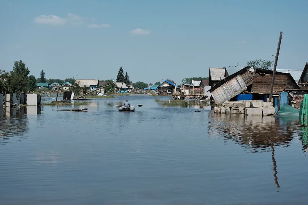 Местный житель плывет на лодке в районе затопления, г. Тулун из-за прорыва неисправной дамбы. Июль 2019 год. Фото: Антон Карлинер, специально для «Новой»