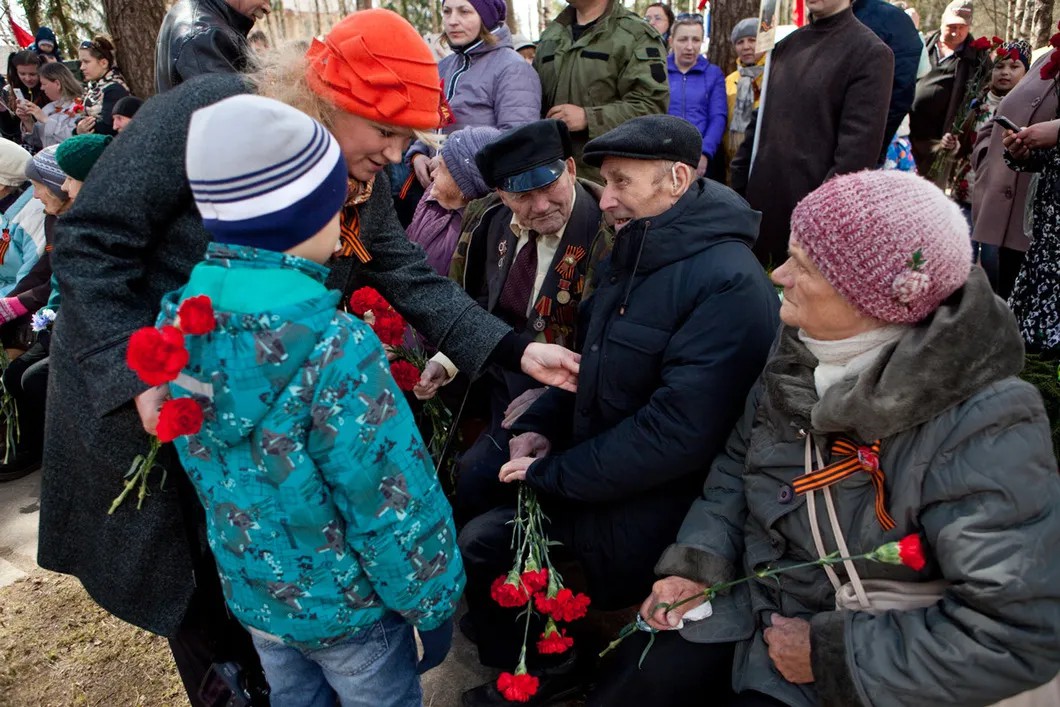 Женщина показывает сыну медали ветеранов. Фото: Елена Лукьянова / «Новая газета»