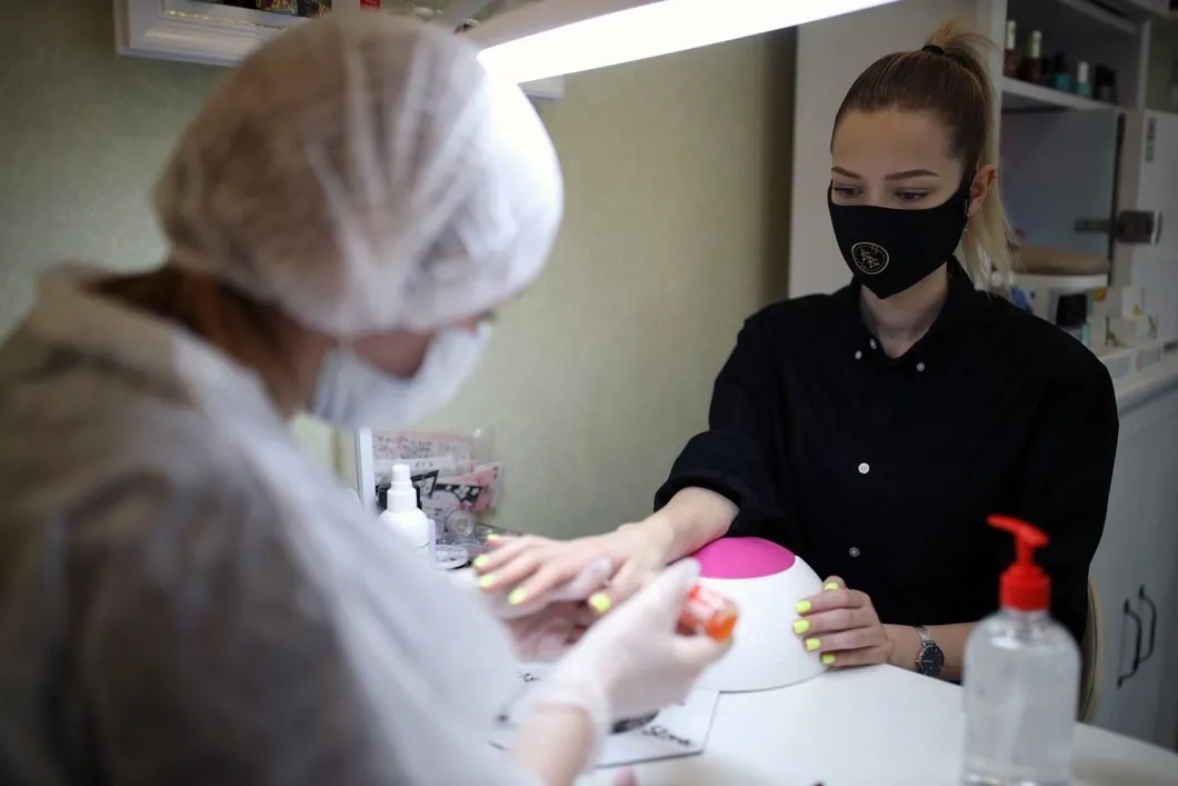 Мастер ногтевого сервиса делает маникюр клиентке. Фото: Виталий Тимкив / РИА Новости