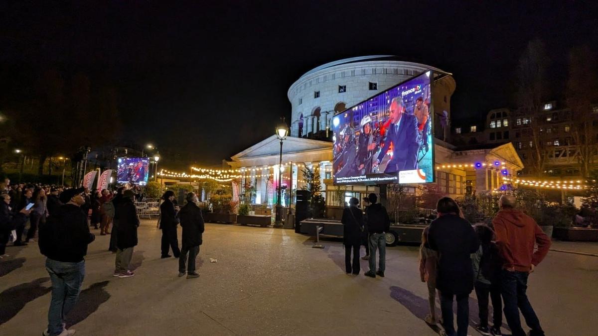 Зрители у штаб-квартиры только что победившего Грегуара наблюдают на экране трансляцию его поездки в мэрию Парижа на велосипеде. Фото: Юрий Сафронов / «Новая газета»
