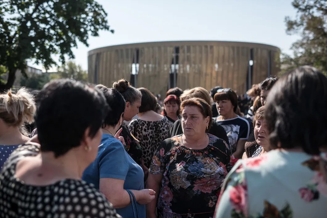Люди собираются у разрушенного здания школы №1, чтобы помянуть погибших. Фото: Алина Десятниченко, специально для «Новой»