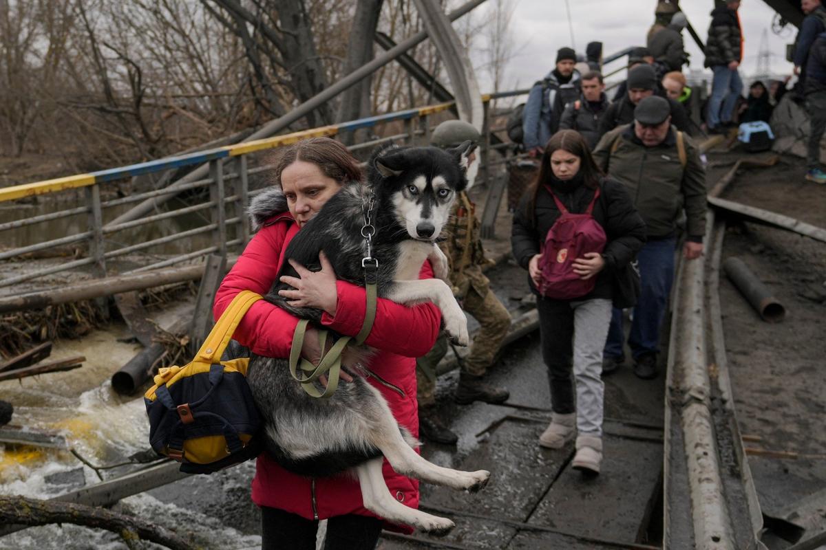 Март 2022 года. Беженцы под разрушенным мостом в пригороде Киева. Фото: AP / TASS