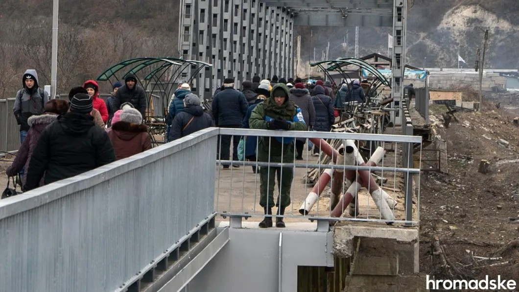 Представитель СЦКК в пятнистой форме российского образца стоит на части моста, которая считается «серой зоной» — военных здесь быть не может, Луганская область, 27 ноября 2019 года. Фото: Александр Кохан / hromadske