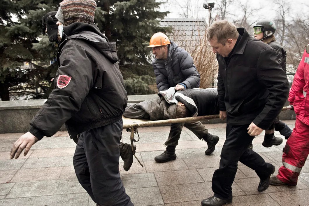Активисты Евромайдана эвакуируют раненого. Фото: Юрий Козырев/ «Новая газета»