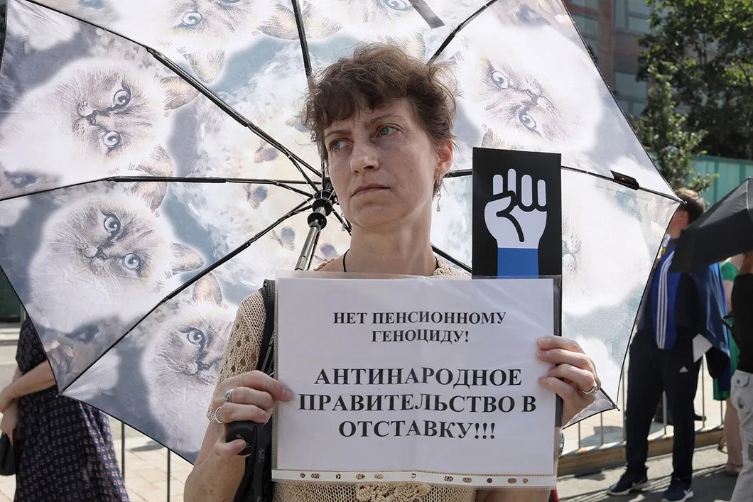 Участница митинга под зонтом. Митинг проходил под палящим солнцем. Фото: Влад Докшин / «Новая газета»
