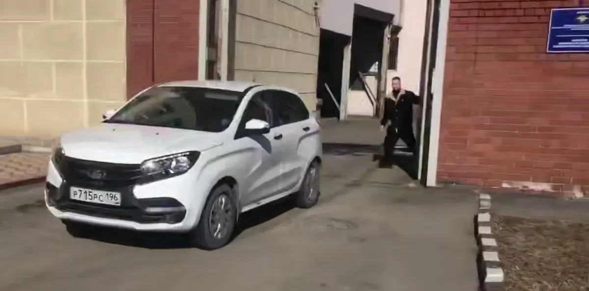 Гражданский автомобиль увозит Владислава Постникова с территории спецприемника — снова в полицию. Скриншот из видео «Новой газеты»