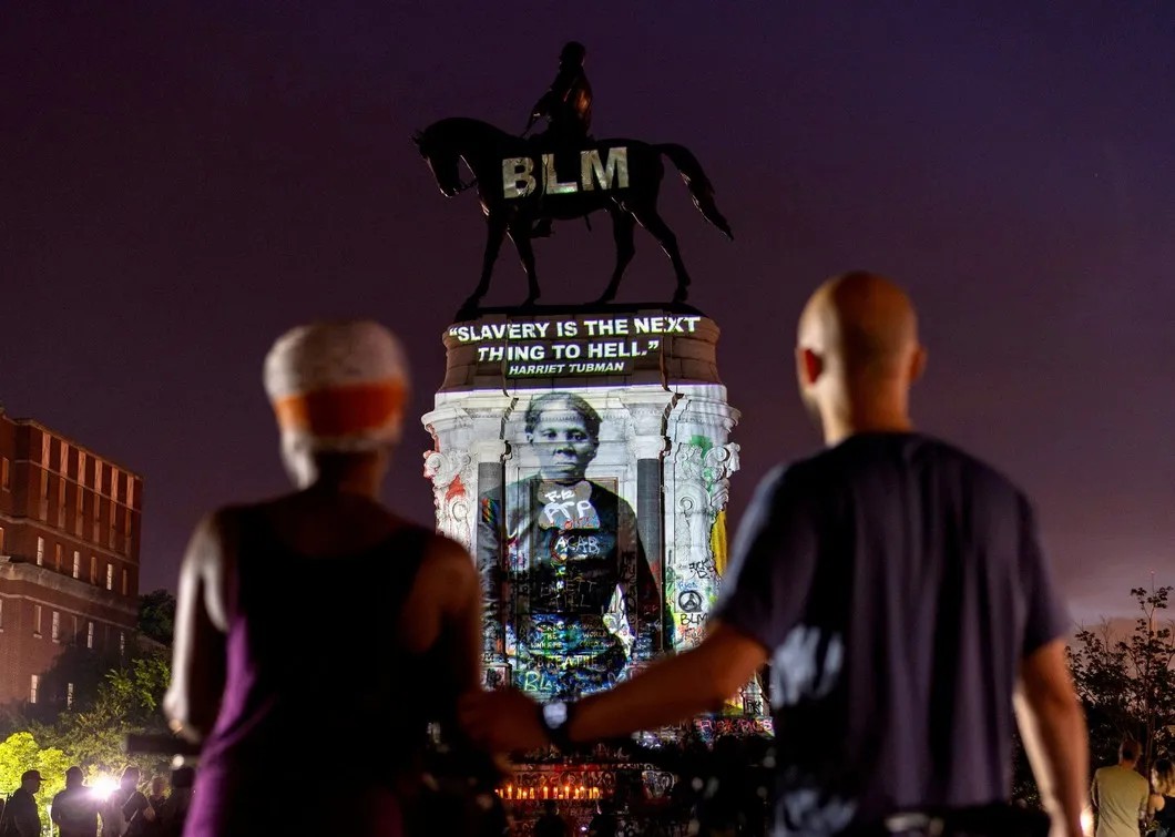 Статуя генерала Эдварда Ли с проекцией фото активистки и борца против рабства Гарриет Табмен. Фото: Reuters