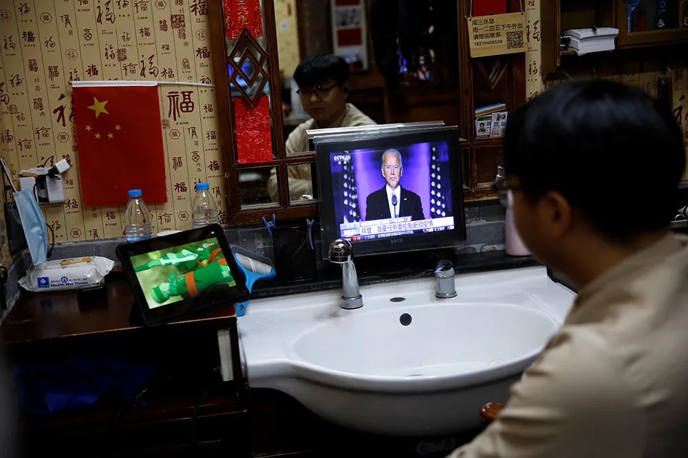 Посетитель кафе в Пекине смотрит выступление Джо Байдена. Фото: Reuters