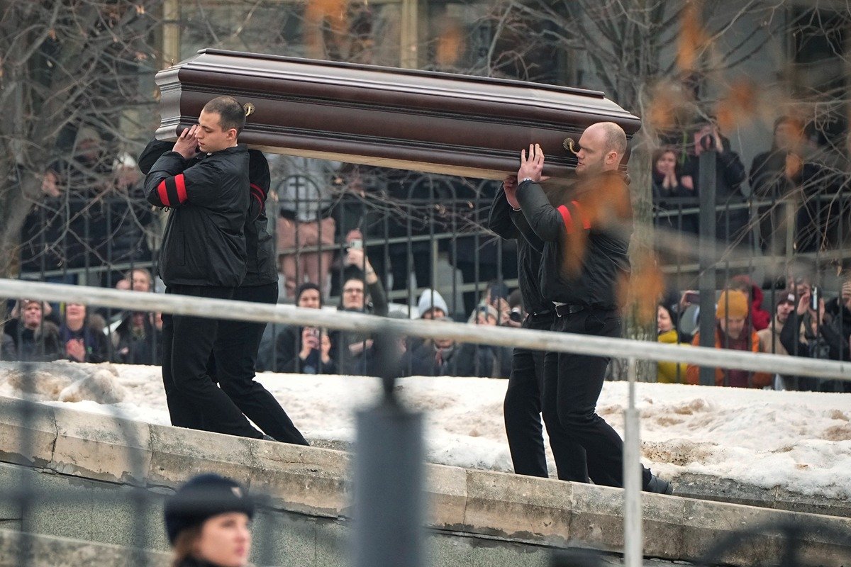 Рабочие несут гроб с телом Алексея Навального на отпевание. Фото: AP / TASS