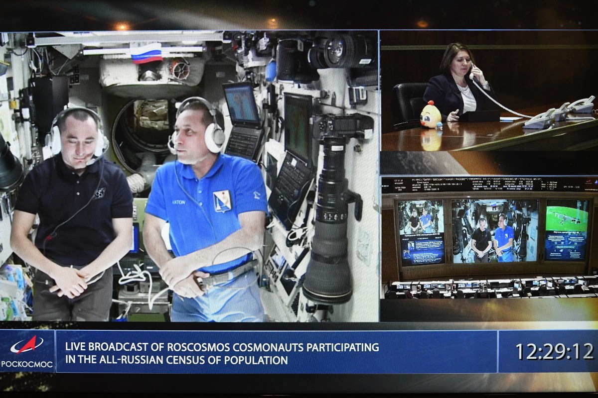 Космонавты Пётр Дубров и Антон Шкаплеров (на экране монитора слева направо) во время сеанса связи с орбитальной международной космической станцией. Кадр РИА Новости