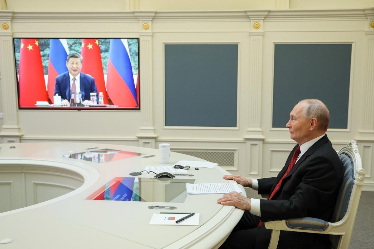 Владимир Путин и председатель КНР Си Цзиньпин (на экране) во время переговоров в режиме видеоконференции. Фото: Вячеслав Прокофьев / пресс-служба президента РФ / ТАСС