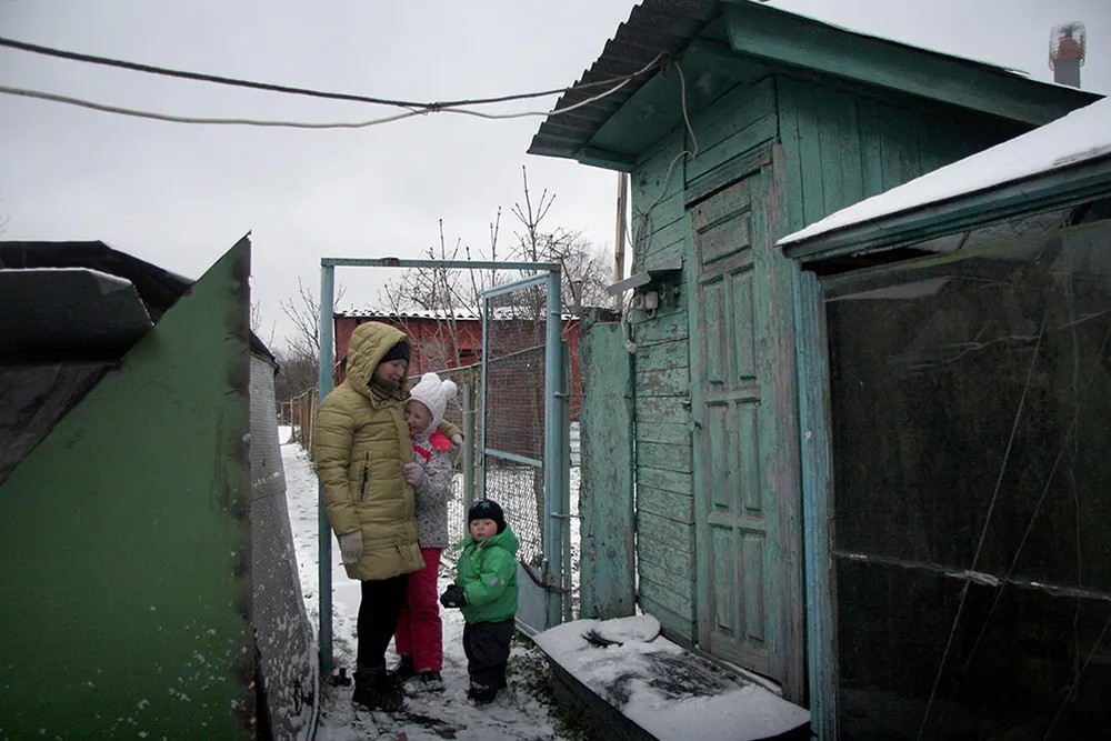 Тамара с дочкой и сыном на своем участке рядом с холодным туалетом. Фото: Светлана Виданова / «Новая газета»