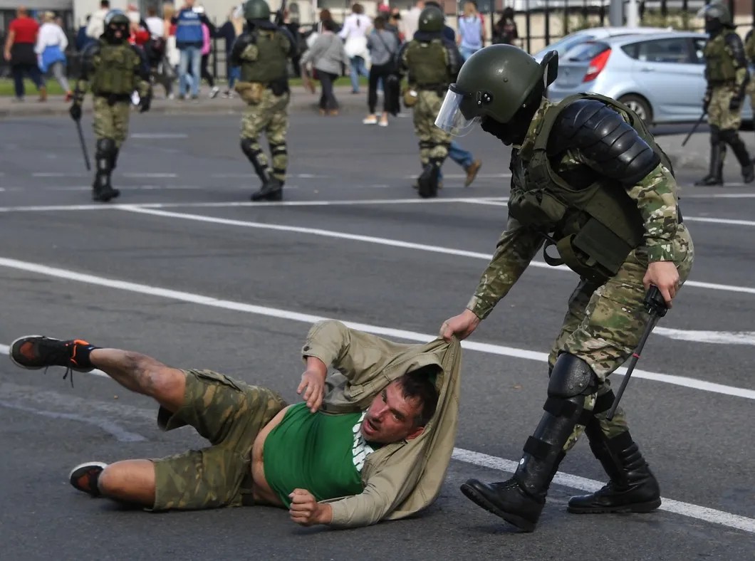 Сотрудник правоохранительных органов задерживает участника уличной акции в Минске. Фото: РИА Новости