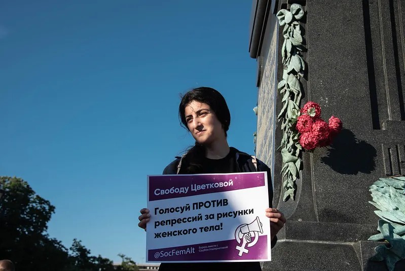 Девушка с плакатом в поддержку преследуемой за рисунки женского тела художницы Юли Цветковой. Фото: Виктория Одиссонова / «Новая газета»