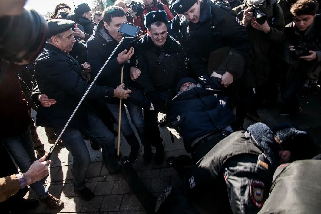 Полиция пытается задержать одного из митингующих, развернувшего плакат. Фото: Влад Докшин