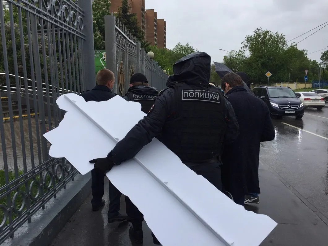 Полиция уносит изъятую картонную фигуру Азара. Фото: Андрей Морев