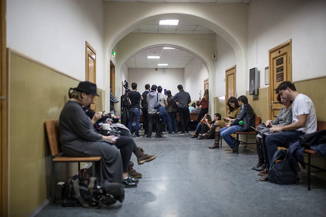 Журналисты и вольнослушатели наблюдают за трансляцией заседания в коридоре суда. Фото: Влад Докшин / "Новая газета"