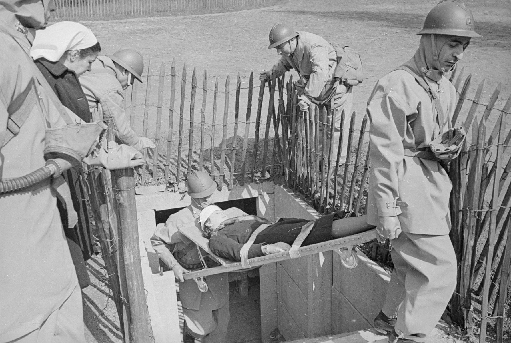 После авианалета. Медбратья выносят раненую из бомбоубежища, Париж, 1940 год. Фото: Fox Photos / GettyImages