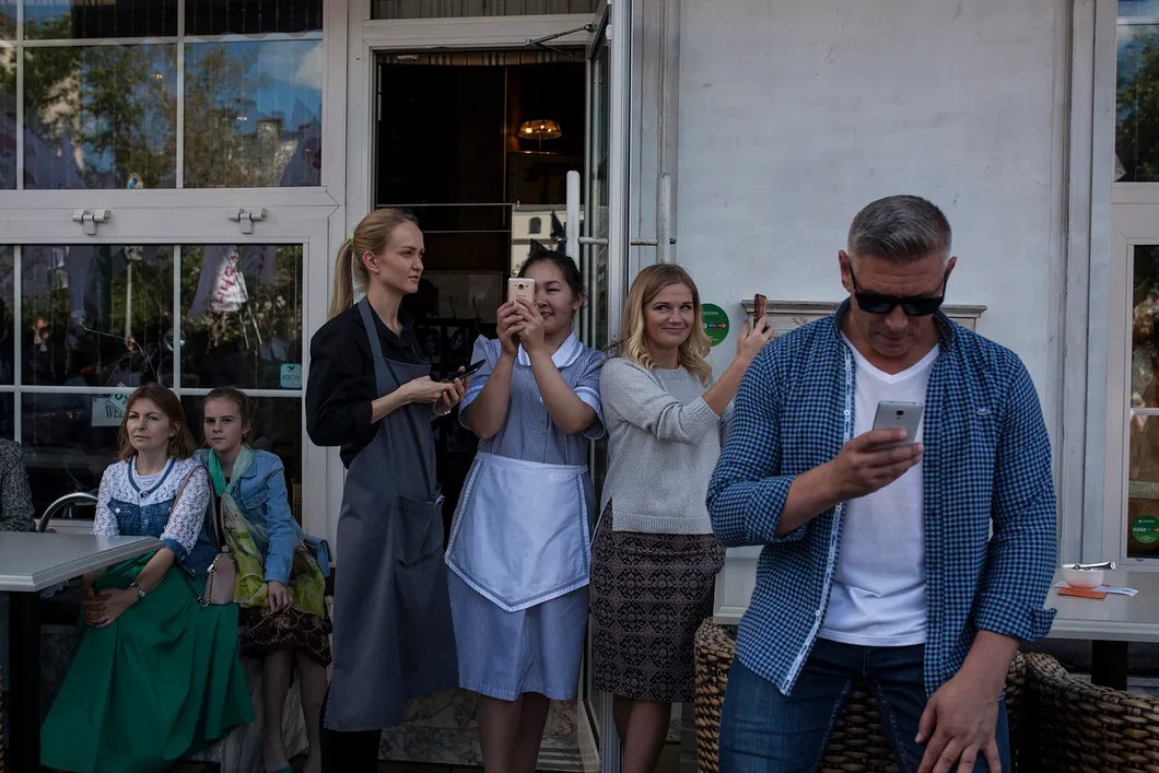 Посетители кафе наблюдают за шествием. Фото: Влад Докшин / «Новая газета»