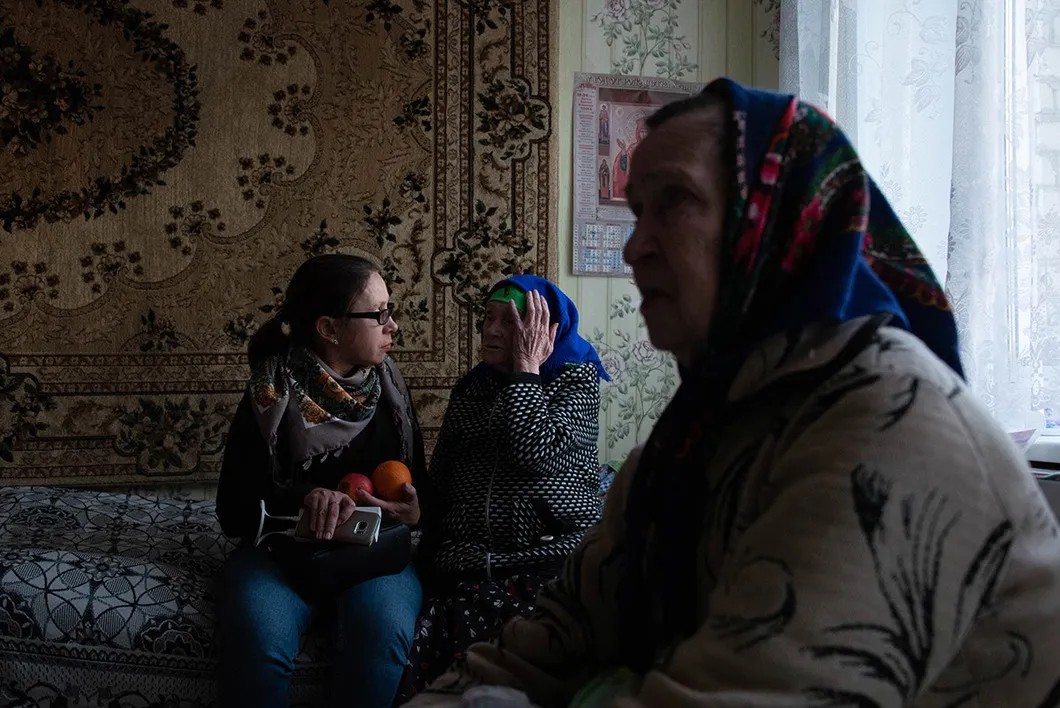 Наталья, волонтер фонда (слева) общается с бабушками в доме престарелых. Фото: Виктория Одиссонова «Новая»
