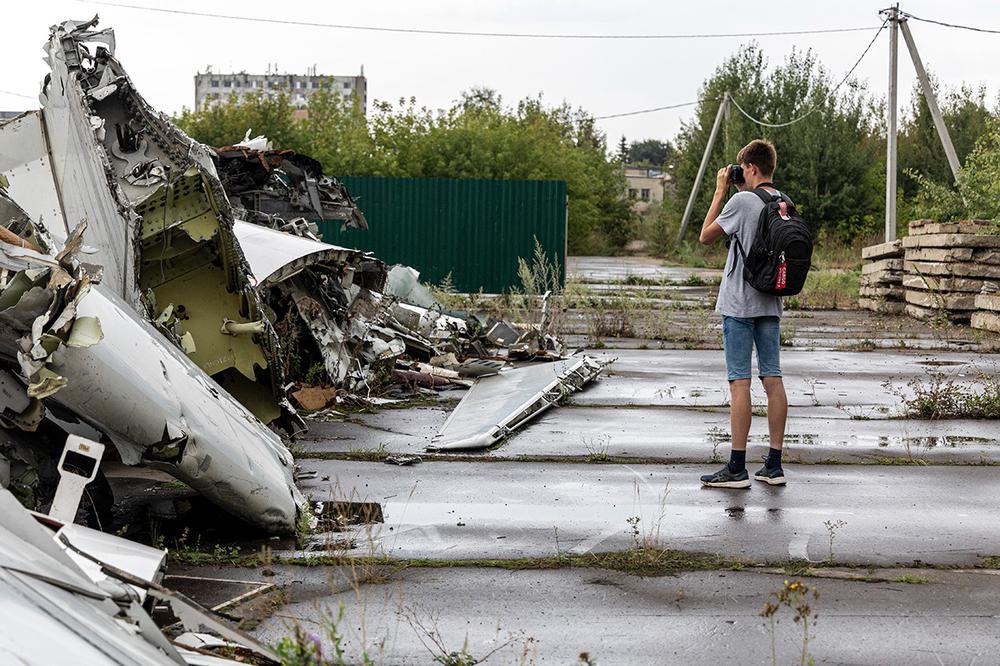 Студент Виктор фотографирует обломки самолета. Фото: Арден Аркман / «Новая газета»
