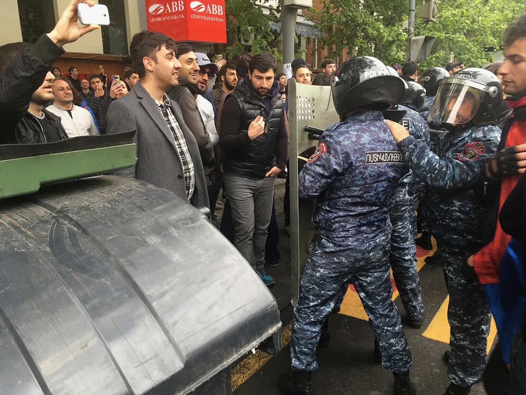 Полиция оттесняет людей, собравшихся на перекрестке, на тротуар. Фото: Илья Азар / «Новая газета»