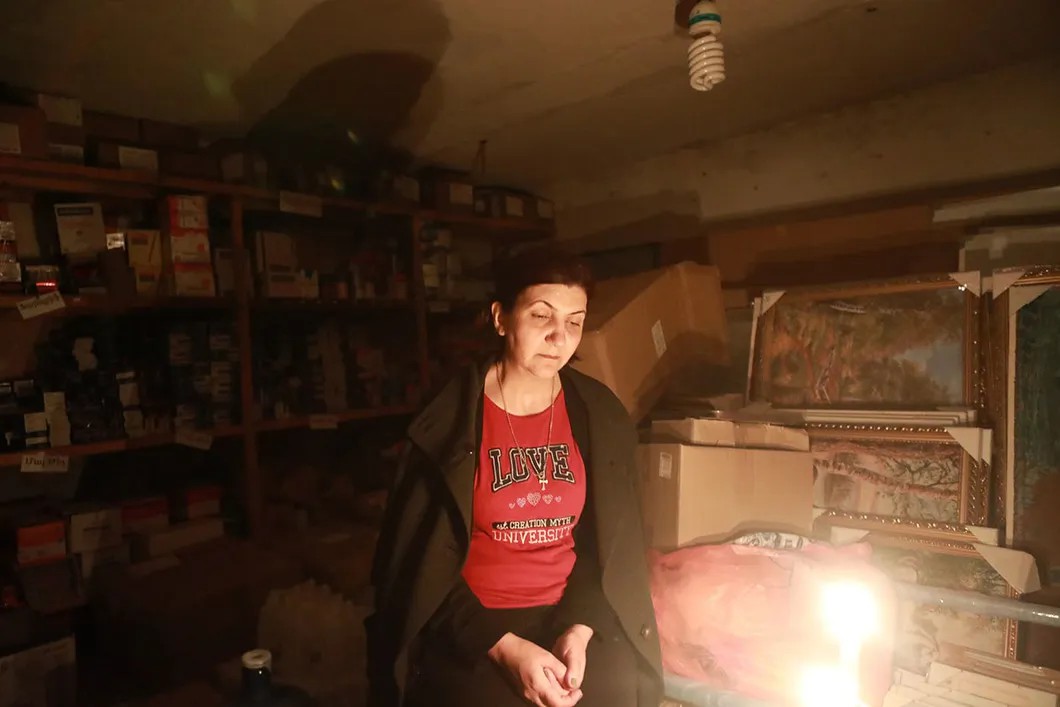 Женщина в убежище возле свечки. Свет пропал после бомбежки электростанции. Есть ли свет у людей сейчас — неизвестно. Фото Павел Волков, специально для «Новой»